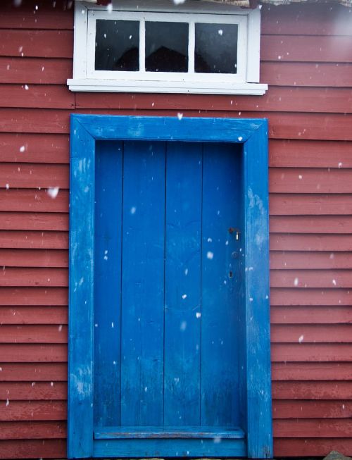 blue door red wall it's snowing