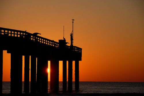 fishing pier sunrise orange sky