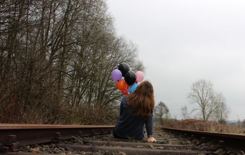 girl railway rails balloons
