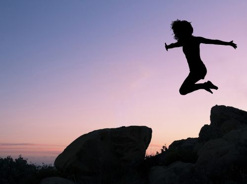 girl leaping rock