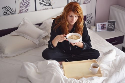 girl in bed breakfast in bed girl with cereal bowl
