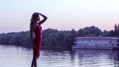 girl in red dress on the shore hands