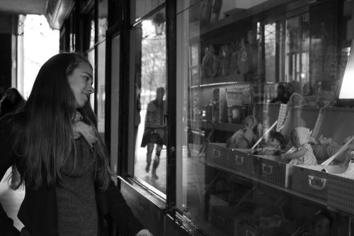 girl looking the dolls window woman
