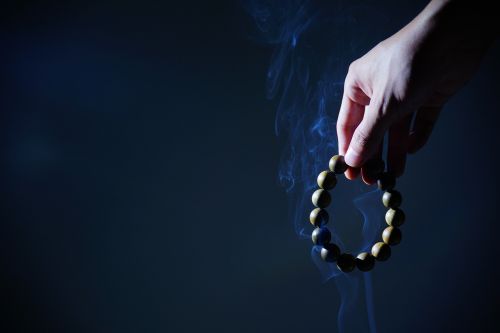 hand buddhist prayer beads smoke