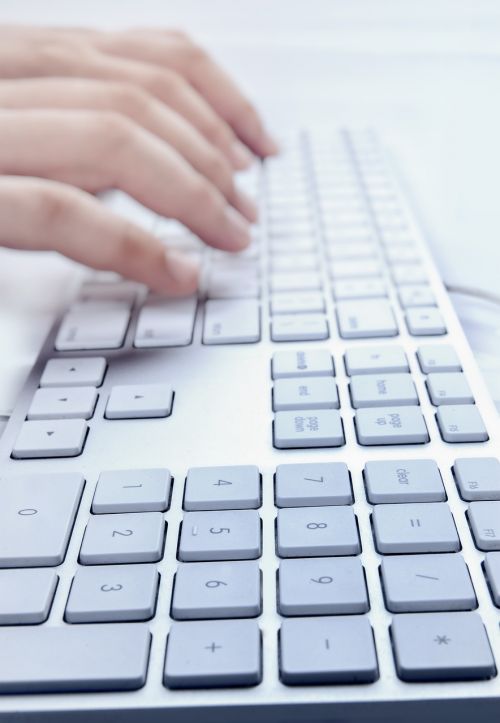 hands typing laptop keypad
