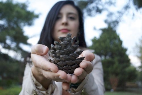 holding pinecone woman