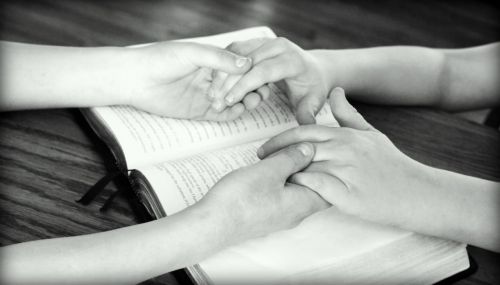 holding hands bible praying