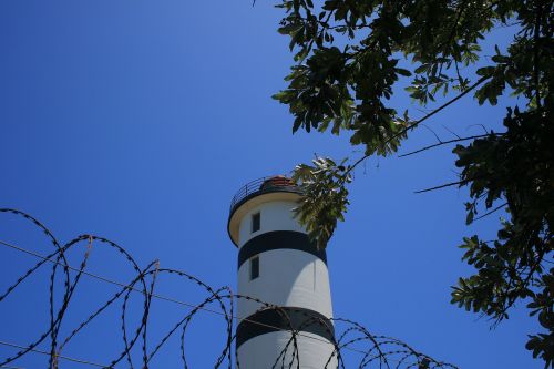 Lighthouse With Tree &amp; Razor Wire