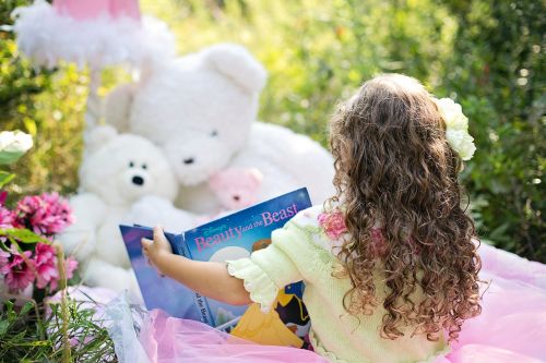 little girl reading garden child