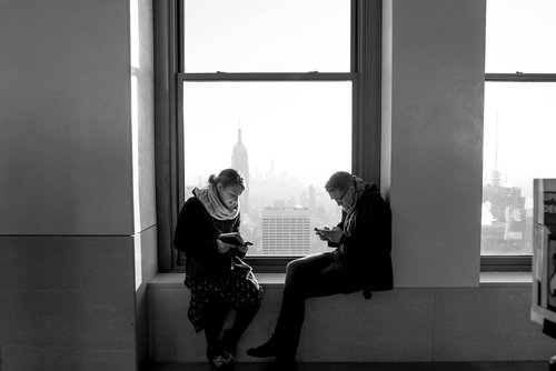 man and woman  sitting  window