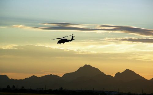 military helicopter flying dusk