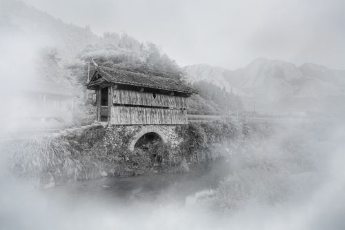 mist covered bridge mountain village
