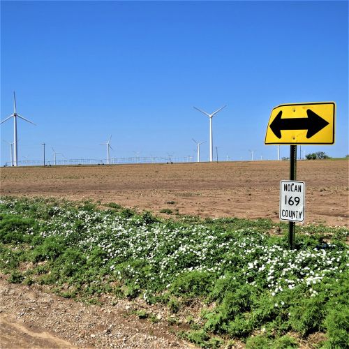 modern windmills blue sky road sign