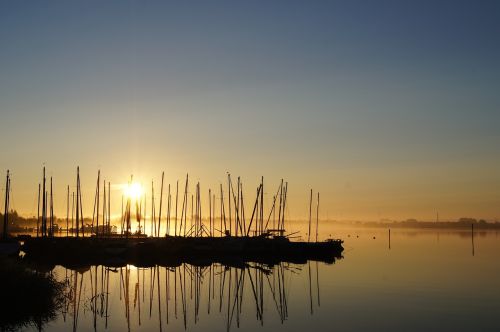 morning sun fog sailing boats