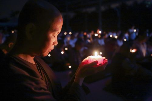 nun with candle theravada buddhism making aspiration
