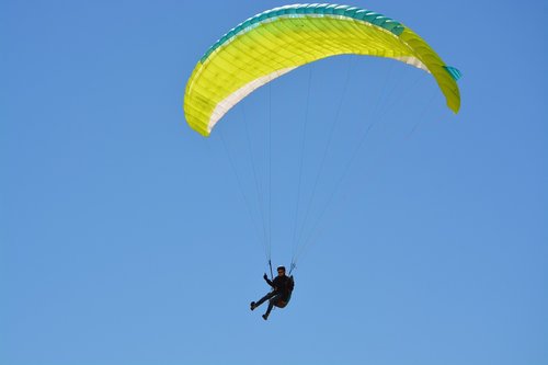 paragliding  paragliding sailing yellow green  paragliders