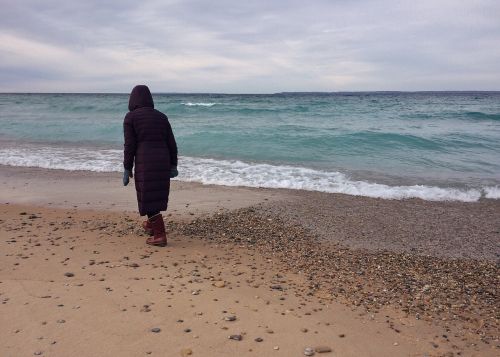 person walking beach shore coast sand