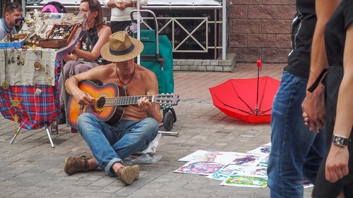 playing guitar  man  sitting on the pavement