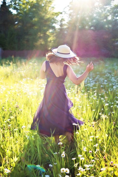 pretty woman in field dancing sunshine