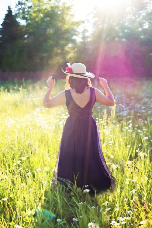 pretty woman in field sunshine long gown