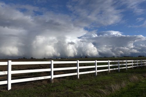 rain clouds white fence pasture