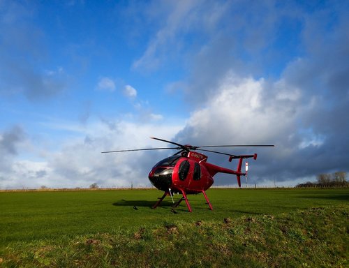 red helicopter  hughes md 500  helicopter on grass
