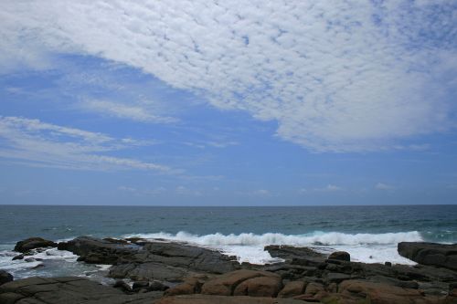 Sea And Rocks Under Cloudy Sky
