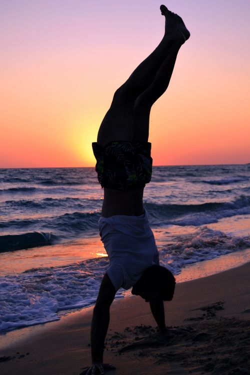 silhouette man standing in hands sunset beach