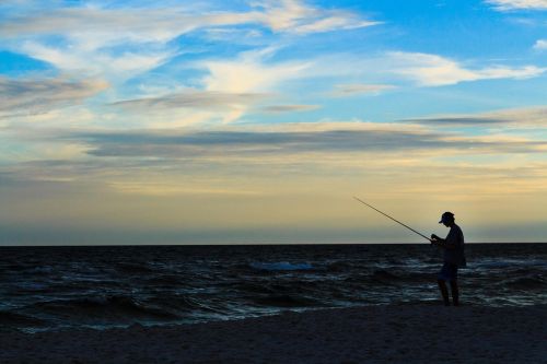 silhouette fishing beach