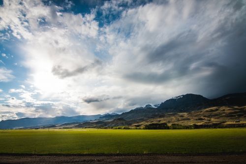 sky clouds green field