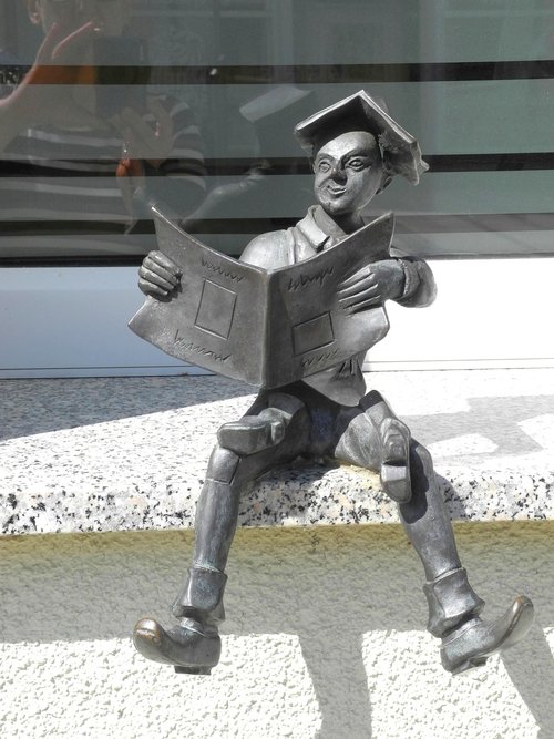 small sculpture  boy  reading on the window sill