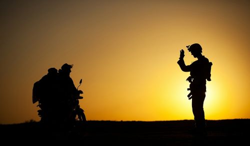 soldier waving to civilians motorcycle silhouette