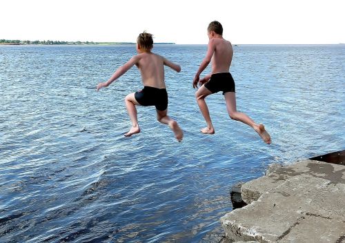 students jumping river