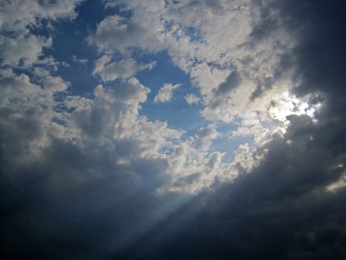 Sun Behind Clouds With Beams