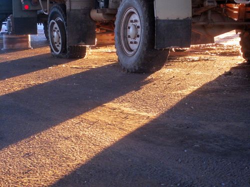 Sun Through Wheels Of Trucks