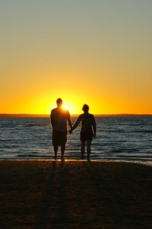 sunset couple holding hands