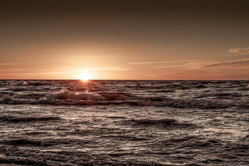 sunset over the sea  sea  the waves