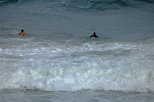 Surfers Rowing On Surf Boards