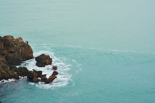 water  rocks  fisherman