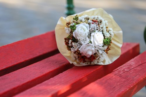 white flower bridal bouquet  colorful  red bench