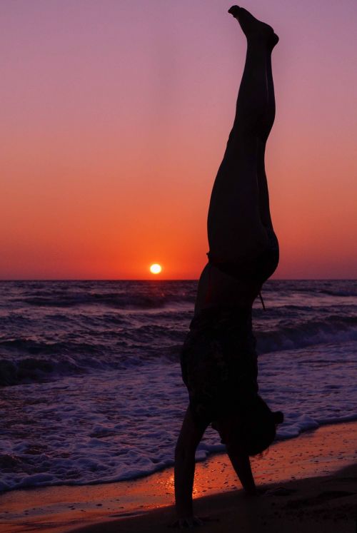 woman silhouette standing on hands sunset beach seascape landscape