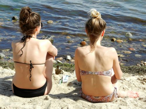 women sunbathe sea