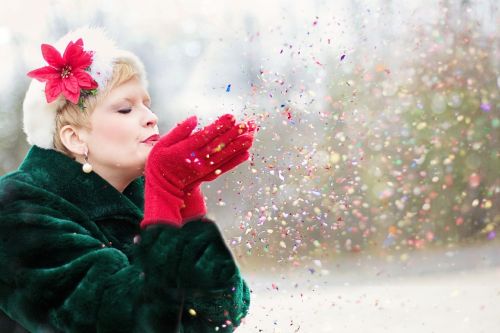 young woman blowing glitter xmas